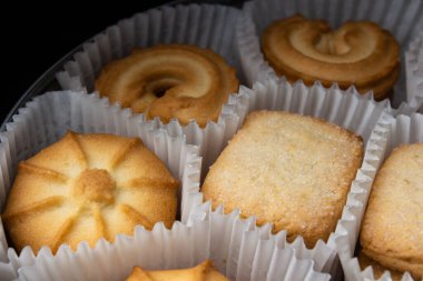 Karanlıkta kağıt sepetlerde bir kutu şekerli kurabiye.