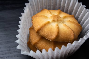 Siyah arka planda kağıt sepetlerdeki şekerli kurabiyeler