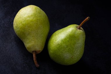 Siyah arka planda iki yeşil armut, sağlıklı yiyecek.
