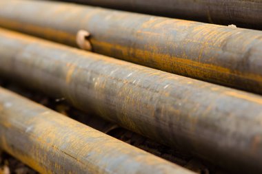 Su için paslı metal borular, yerde çapraz uzanır.