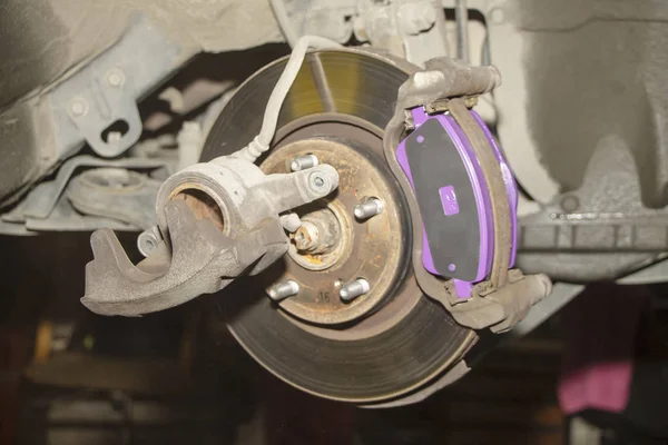 A hand technical specialist repairing the brake system of the modern car.