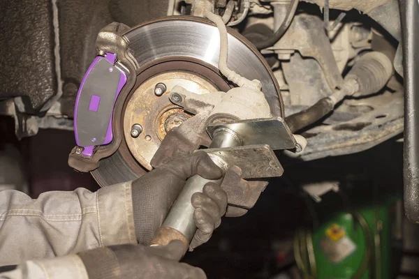 A hand technical specialist repairing the brake system of the modern car.
