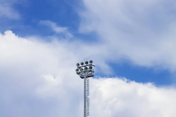 Lighting spotlights sports stadium against the blue sky.