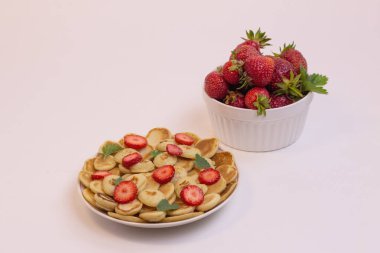 Çilekli küçük tahıllı krepler, hızlı sağlıklı kahvaltı, gri arka planda krep lapası.