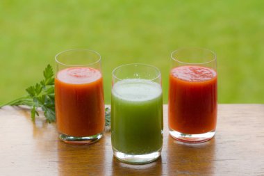 Koyu ahşap arka planda domates ve salatalık suyu. Sağlıklı beslenme. Vejetaryenlik.