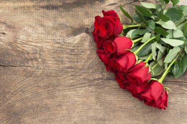 Ahşap arka planda kırmızı güller. Yukarıdan görüntüle