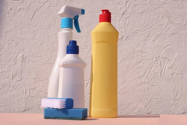 Cleaning supplies in blue, yellow on a white wooden background. The concept of cleaning. Place for inscription