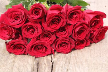 Tebrik kartları için. Ahşap bir masada kırmızı güller. Boşluğu kopyala