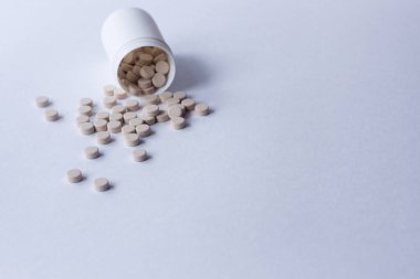 Beyaz arka planda haplar ve şişe. Yazı için yer.