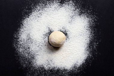 Ekmek veya pizza yapmak için mangır siyah arka planda, üst görünüm