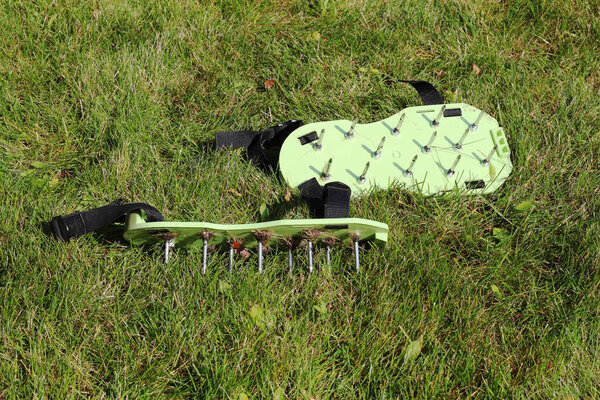 Spiked shoes liven up the lawn. Lawn aeration. gardening concept. Garden care.