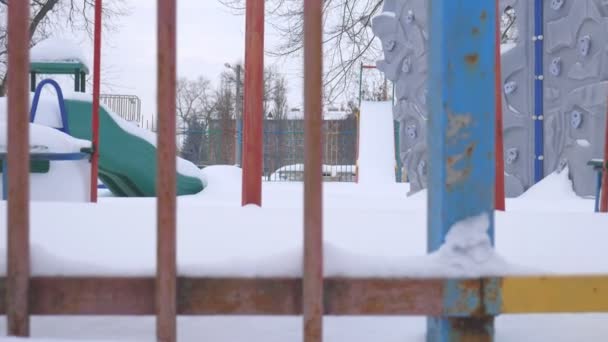 Parque infantil en la nieve pesada . — Vídeo de stock