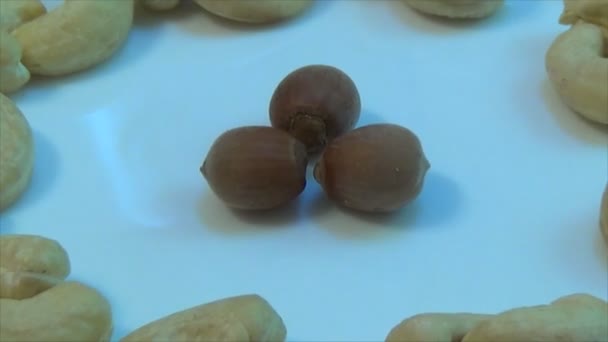 Κοντινό κομμάτι των διαφορετικών ξηρών καρπών σε ένα πιάτο — Αρχείο Βίντεο
