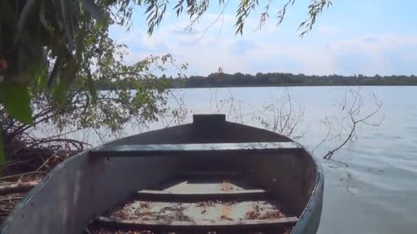 Antiguo bote de remos de madera flotando en el agua en la orilla del río en un hermoso día soleado de verano — Vídeos de Stock