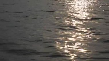 Yaz aylarında dinlendirici su dalgalarının yüzeyinde güneş yansımaları ve parıltıları.