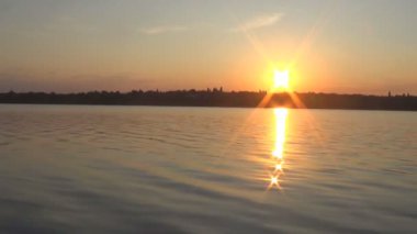 Sakin bir nehrin arkasında yaz günbatımı