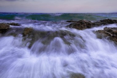 Rock günbatımı manzara arka planda çökmesini uzun pozlama hareket dalga deniz manzarası