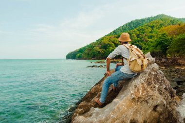 sakin bir günde denizin güzel kaya ve manzara üzerinde bir adam sittijng, Tayland, Phang nga, Koh yao yai