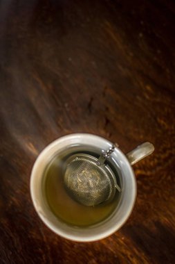 Bardak çay demlik yeşil çay, nane otlar ve koyu ahşap arka plan üzerinde bal ile sıcak dumanlı su ile