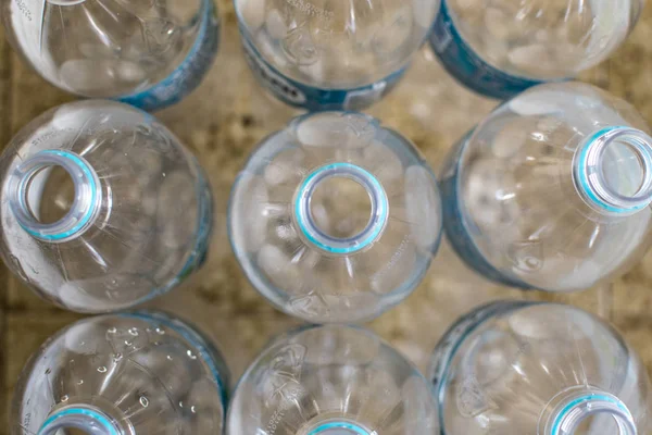 Lot de bouteilles d'eau en plastique transparent vide pour animaux de compagnie avec étiquette bleue, sans capuchon et fond flou — Photo