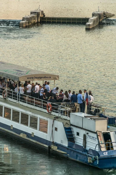 Praga, República Checa - 10 de septiembre de 2019: Hora feliz en barco turístico por la noche en un recorrido por el río Moldava, con la luna, levantándose en el cielo —  Fotos de Stock