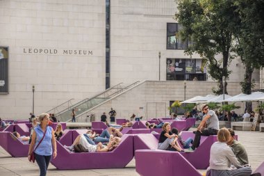 Vienna, Avusturya - Eylül, 15, 2019: Turist, Genç çiftler, gençler ve aileleri banklar rahatlatıcı Müze Bölgesi şehir merkezinde