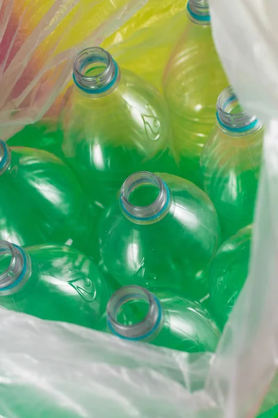 Un pack de 8 bouteilles d'eau en plastique vides et recyclables, sans capuchon, scellé bleu, à l'intérieur d'un sac en plastique, sur un fond coloré. ordures, réutilisation, respectueux de l'environnement, concept environnement . — Photo