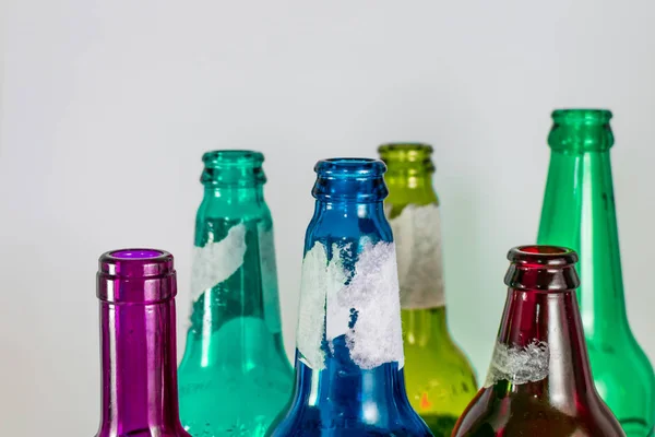 Image du goulot d'étranglement de bouteilles de bière et de vin vides sur fond blanc. Couleurs vert, jaune, rose et bleu. Réutilisation, acoholisme, médecine, recyclage et concept de fête . — Photo