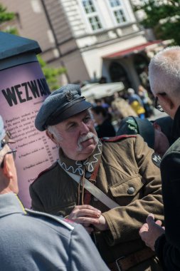 Krakow, Polonya - 23 Eylül 2018: I. Dünya Savaşı'ndan kalma Polonya üniformalı adam krakows ana meydanında turistlerle konuşurken elinde bir av tüfeği tutuyor