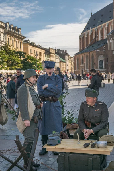 Cracovia, Polonia - 23 de septiembre de 2018: Hombres vestidos con uniformes polacos de la Primera Guerra Mundial entre los turistas en la plaza principal de Krakows — Foto de Stock