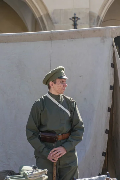 Cracovia, Polonia - 23 de septiembre de 2018: Joven vestido con uniformes polacos de la Primera Guerra Mundial entre los turistas en la plaza principal de Krakows — Foto de Stock