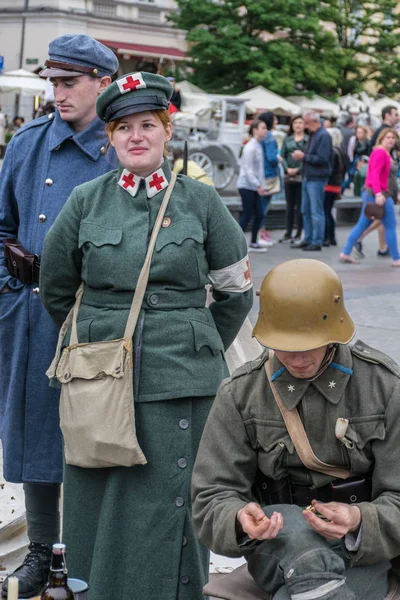 Cracovia, Polonia - 23 de septiembre de 2018: Hombres y mujeres vestidos con uniformes polacos de la Primera Guerra Mundial entre los turistas en la plaza principal de Krakows — Foto de Stock