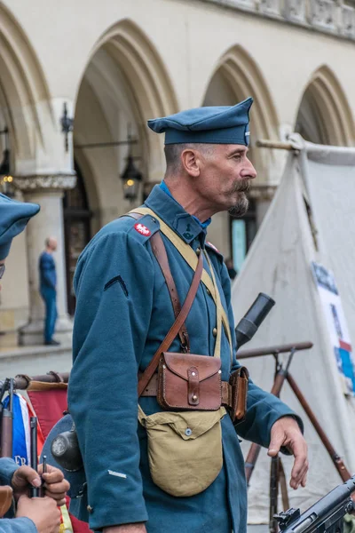 Cracovia, Polonia - 23 de septiembre de 2018: Hombre Alto vestido con uniformes polacos de la Primera Guerra Mundial entre los turistas en la plaza principal de Krakows — Foto de Stock