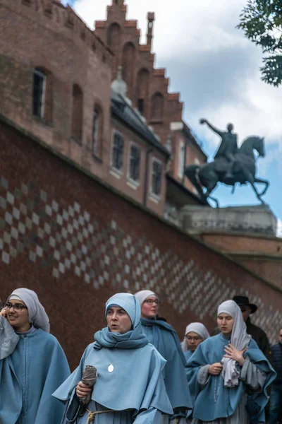 Κρακοβία, Πολωνία-23 Σεπτεμβρίου, 2018: μοναχές που περπατούν στην πρόσβαση στο βασιλικό κάστρο του Βάβελ στην Πολωνία, Κρακοβία, με το μνημείο του Ταντέους Κοσκιουσάκος θαμπωμένη σε προοπτική στο παρασκήνιο — Φωτογραφία Αρχείου