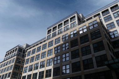 Berlin, Almanya - 26 Eylül 2018: Berlin'in merkezinde, doğal aydınlatmalı kare ve yansıtıcı pencerelere sahip geniş bir iş binasının mimarisinin yukarı perspektifi