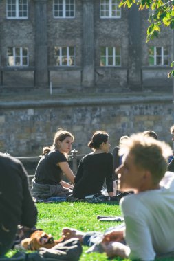 Berlin, Almanya - 26 Eylül 2018: James Simon Parkı'nda çimlerde oturan bir grup Berlinlinin yatay görünümü, Müze Adası'nın yanında ve Berlin Katedrali'nin arkasında