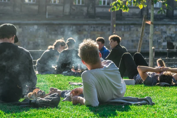 Berlin, deutschland - 26. september 2018: berliner relaxen und sonnen sich im james simon park, neben der Museumsinsel und hinter dem berliner dom mit dem fokus auf eine rauchende person — Stockfoto