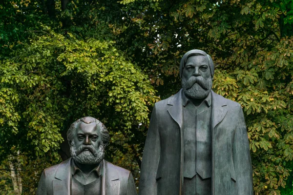 Berlin, Németország-szeptember 26, 2018: nagyítás a szobrok Karl Marx és Friedrich Engels, az értelmiségiek a kommunista mozgalom található, a Innenstadt parkban a háttérben a fa levelei — Stock Fotó