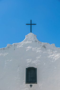 Trancoso, Porto Seguro, Bahia, çatı ve yeşil bir pencere üzerinde basit bir ahşap haç ile antik alamet ve mütevazı Quadrado kilisenin beyaz cephe closeup ve ayrıntılı yukarı görünümü