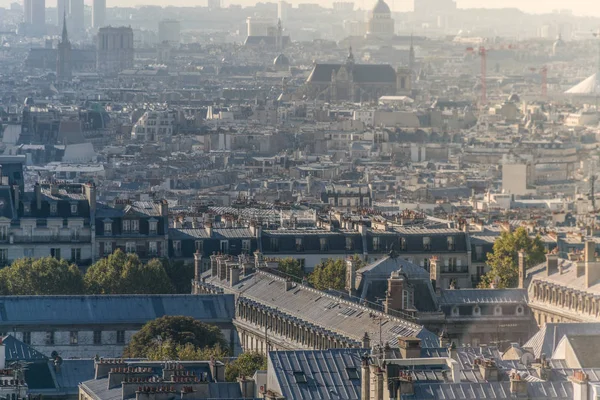 Orizzonte vista di Parigi, in Francia con una prospettiva architettonica sui tetti degli edifici nel quartiere di Montmartre e alberi sparsi durante il giorno con un po 'di nebbia nell'aria — Foto Stock