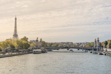 Eyfel Kulesi ve arka planda Alexander III köprü kenarlarında turistik cazibe tekneleri ile Fransa'da Paris şehrini geçen Seine nehri güzel kartpostal görünümü