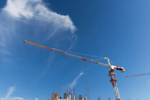 Construction tower crane against the blue sky. Concept of development of the architectural appearance of the city. Construction of multi-family residential buildings. Monolithic concrete works. — Stock Image Construction Tower Crane Blue Sky Concept Development Architectural Appearance City Stock Picture