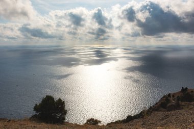 Denizin üzerinde gri güzel bulutlar. Uzun panoramik deniz sonbahar manzarası. Alçak Cumulus bulutları ve parlak güneş ışığı. Suyun yüzeyindeki bulutların gölgesi. Gri çelik sonbahar denizinin doğal gölgeleri.