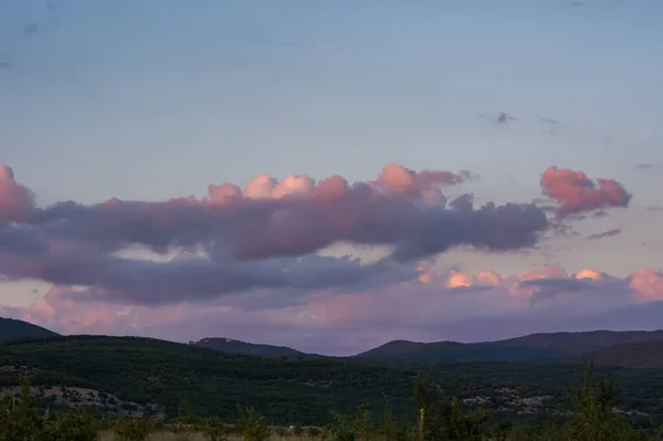 粉色的云彩笼罩着森林 亮晶晶的日落紫色和深红色的色调 日落时的乡村风景 美丽的自然背景和云彩 — 图库照片