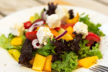 Yazlık kafede beyaz tabakta Yunan salatası. Vejetaryen yemeği. Zeytin, mor soğan ve peynir. Bir kafede hafif atıştırmalıklar. Yaz menüsü. Doğal ışık.