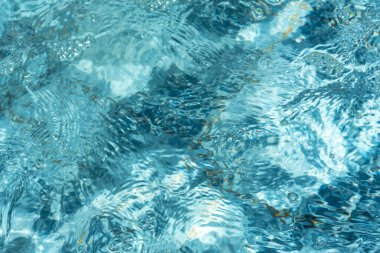 Havuz suyunun dokusu. Mavi şeffaf su güneşte parlar. Soyut doğal arkaplan. Havuzun tam çerçeve görüntüsü. Parlak turkuaz arkaplan.