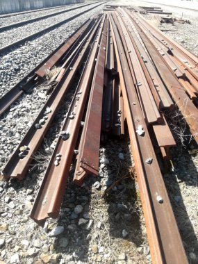Gevşek tren rayları birikmiş. İspanyol demiryolu ekipmanlarının onarımı ve bakımı için demir parçaları.