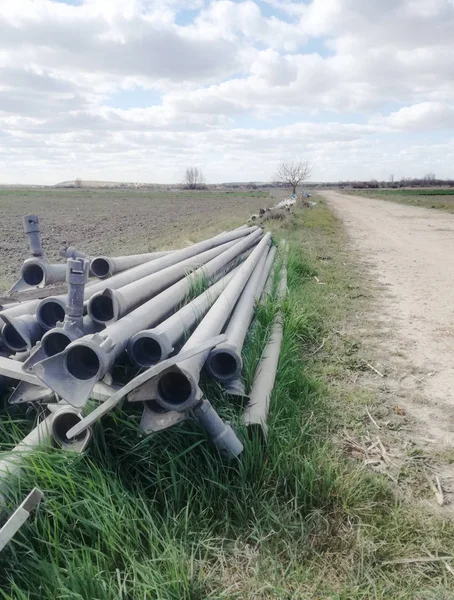 Cultivated Fields Sides Path Rigid Irrigation Pipelines Piled Next Rural — Stock Photo, Image