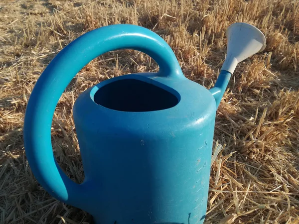 水やり缶 穀物の背景は 新鮮に収穫 青と黄色のコントラスト 果樹園の道具 庭の手動灌漑システムのための古典的な容器 農村環境 — ストック写真
