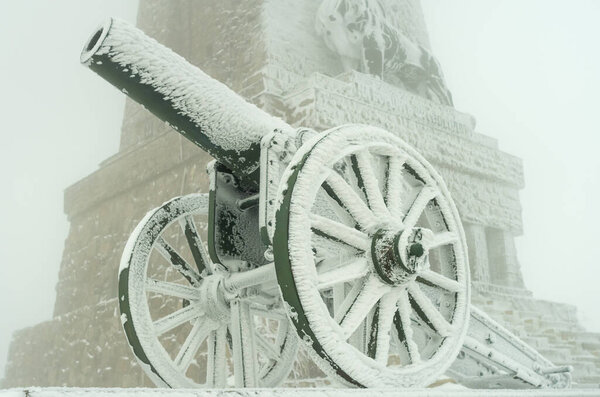Старая металлическая пушка. Пушка участвовала в боях за освобождение Болгарии в 1877 году. Зимний туман, много снега, старые пушки, покрытые снегом.